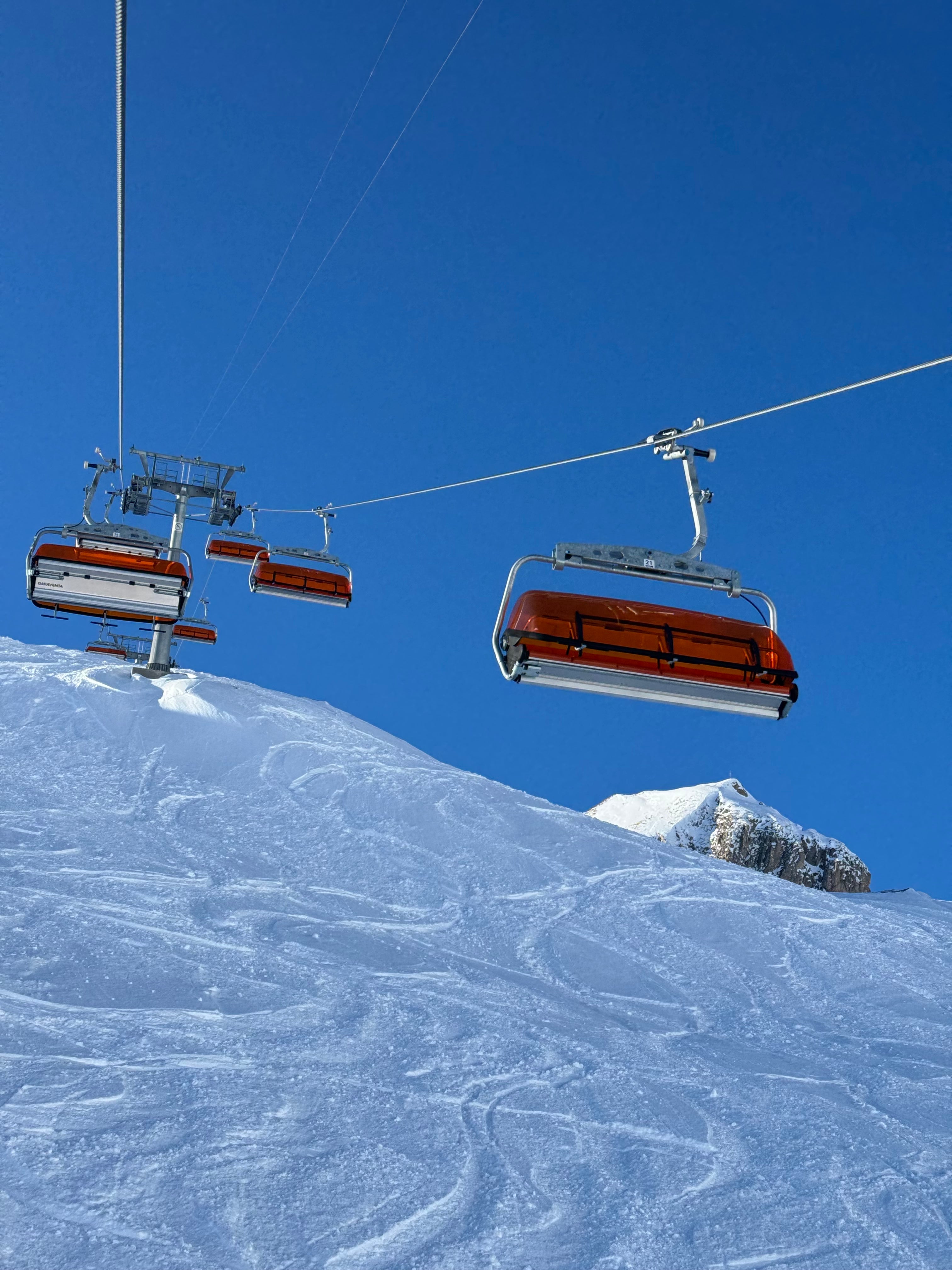 Sessellift in Ischgl über verschneiter Skipiste bei blauem Himmel – perfekter Skitag in den Tiroler Alpen.