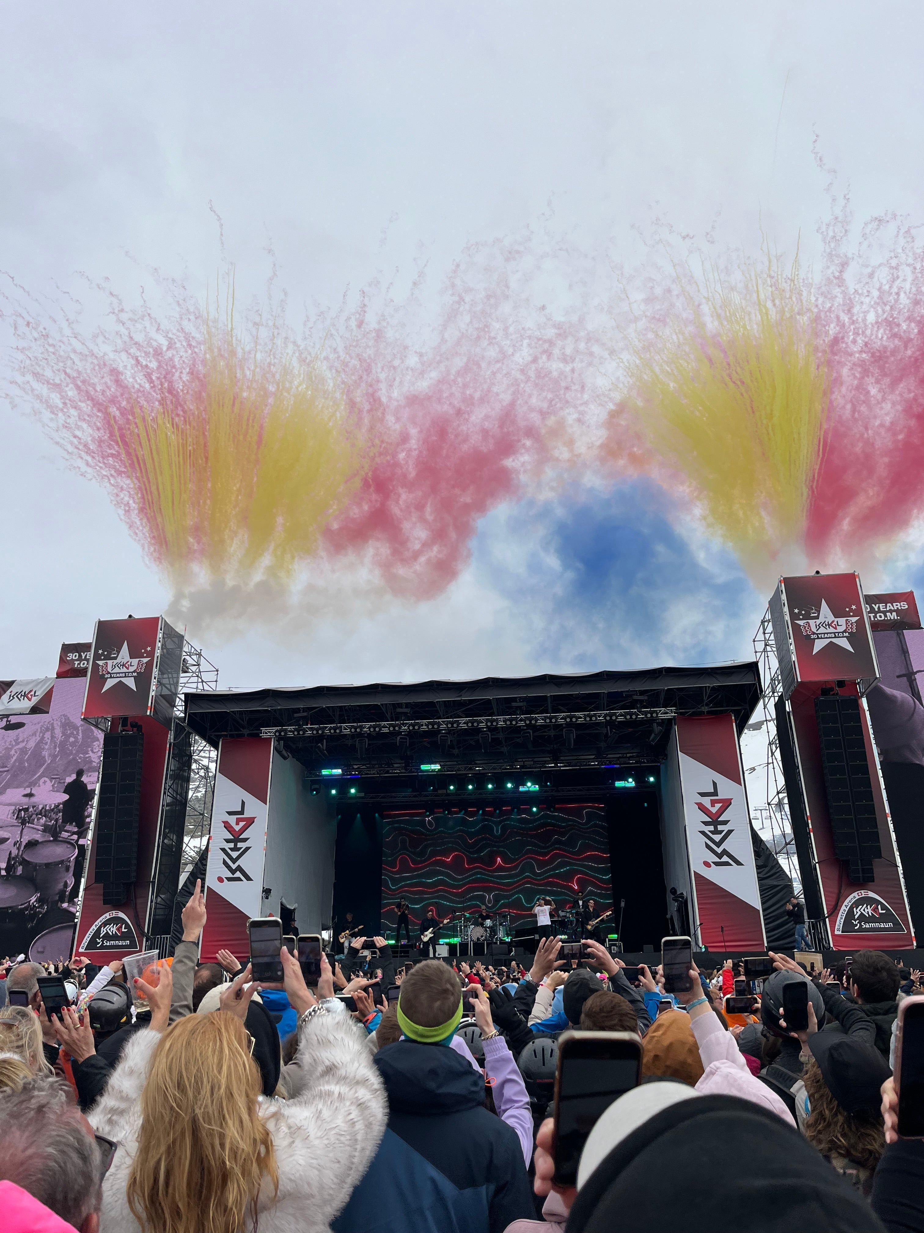 Top of the Mountain-Konzert zum Saison Closing in Ischgl mit großer Bühne, Feuerwerk in Rot, Gelb und Blau am Himmel und feiernder Après-Ski-Menge